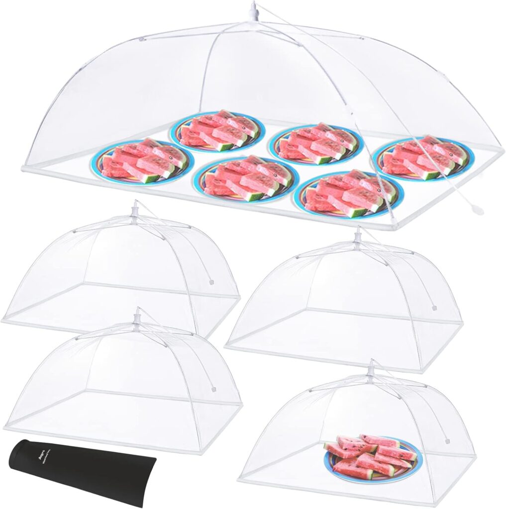 Mesh food tents protecting snacks from flies on an outdoor buffet table