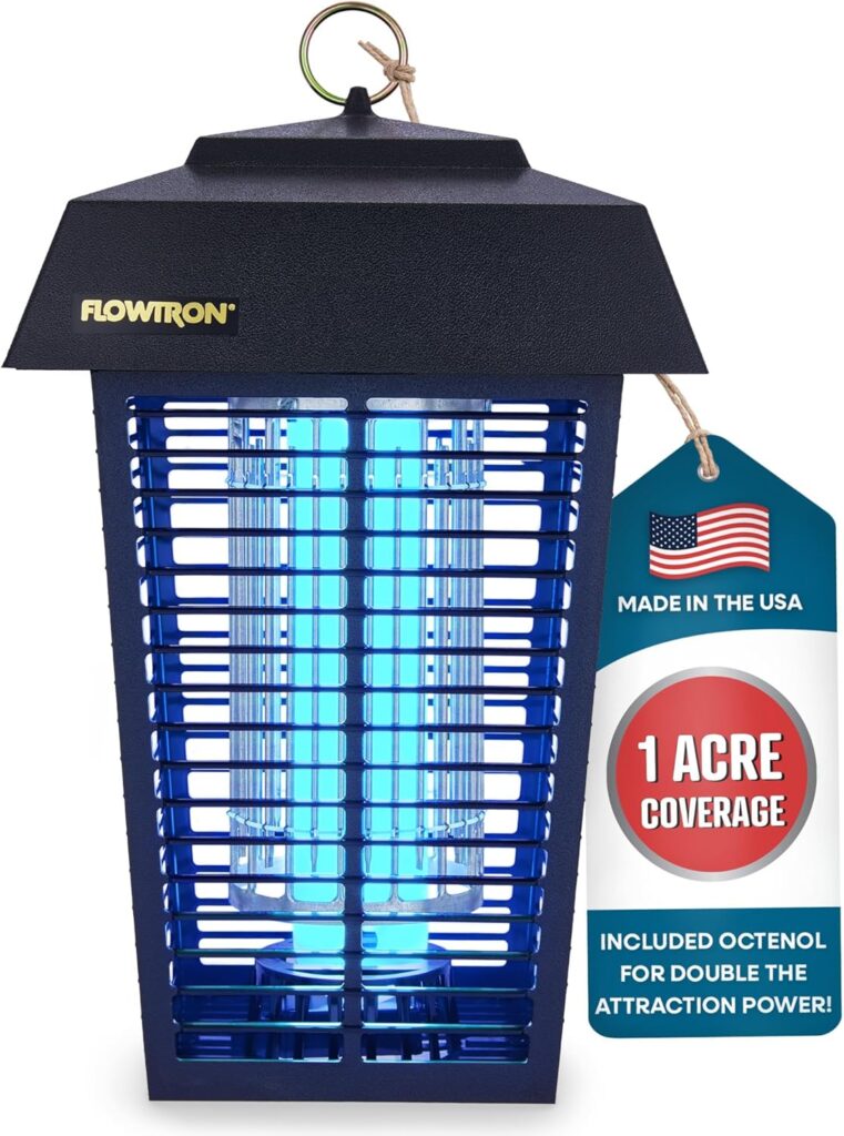Portable bug zapper lantern glowing on a picnic table at dusk